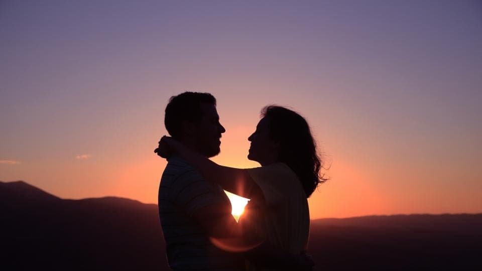 Two people at sunset, foreheads almost touching