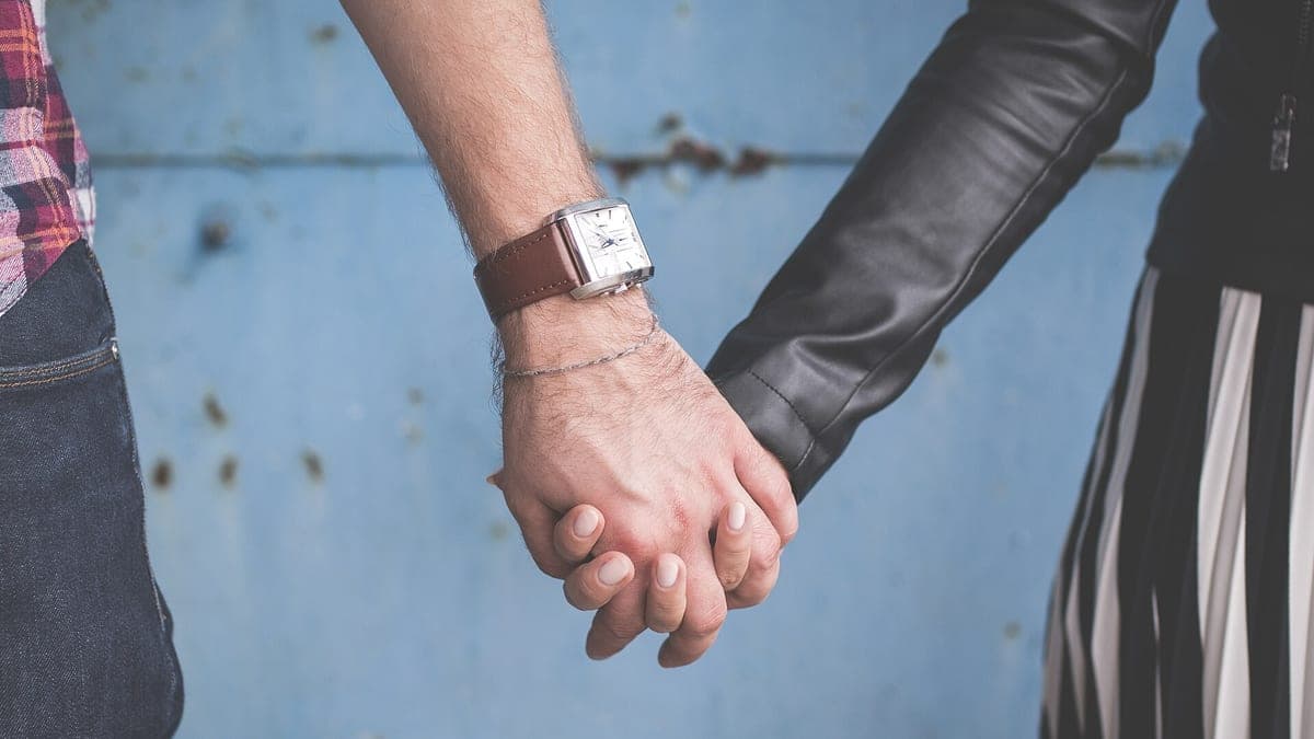 Two hands held, one wearing a watch