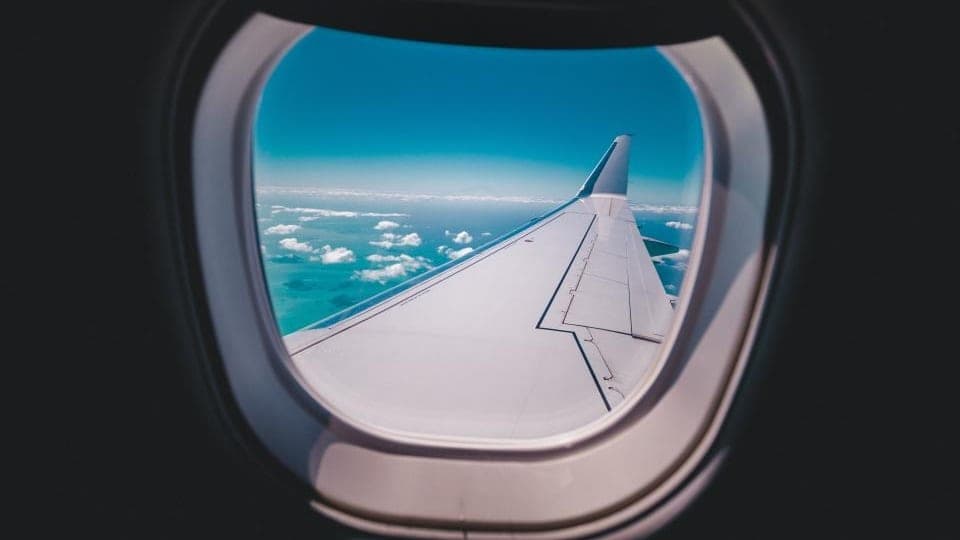 An aeroplane wing seen through a cabin window