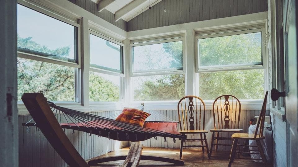 An empty sunroom with two chairs at the window