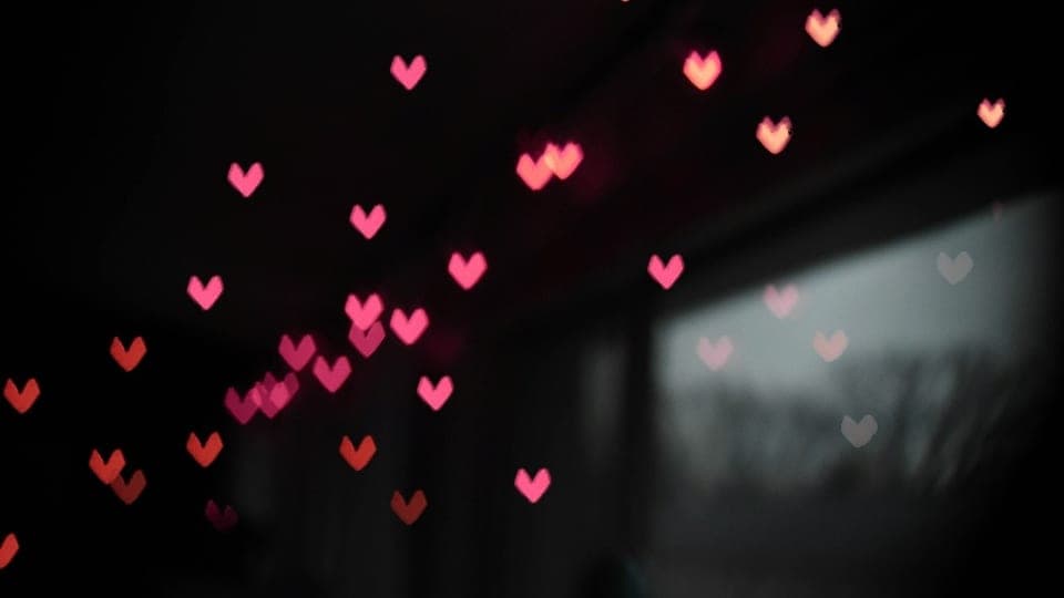 Small paper hearts caught in the light against the dark